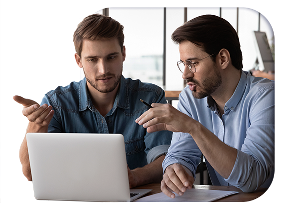 Two managers discussing gap analysis data whilst looking at a laptop
